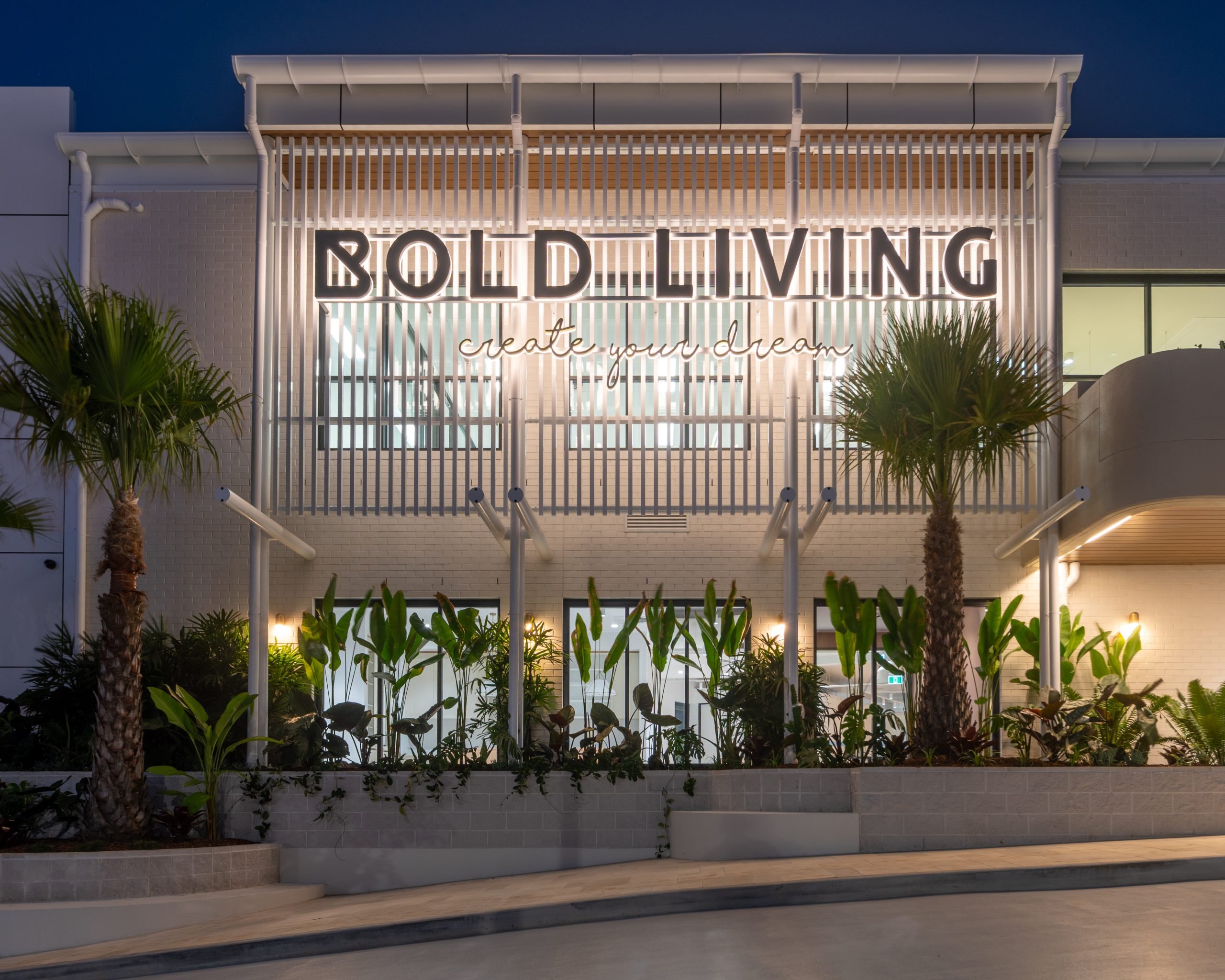Headquarters facade illuminated at night with feature signage and landscape lighting