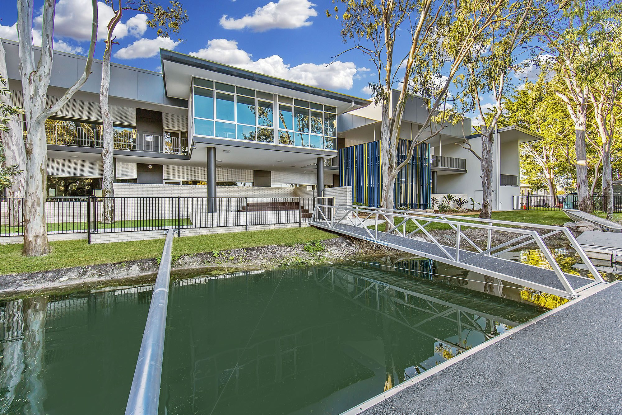 Multi-storey campus building above a landscaped water feature