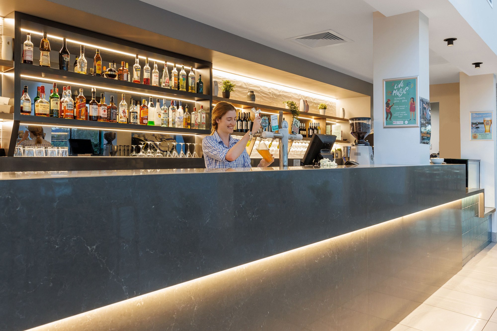 Bar with illuminated shelving and pendant lighting