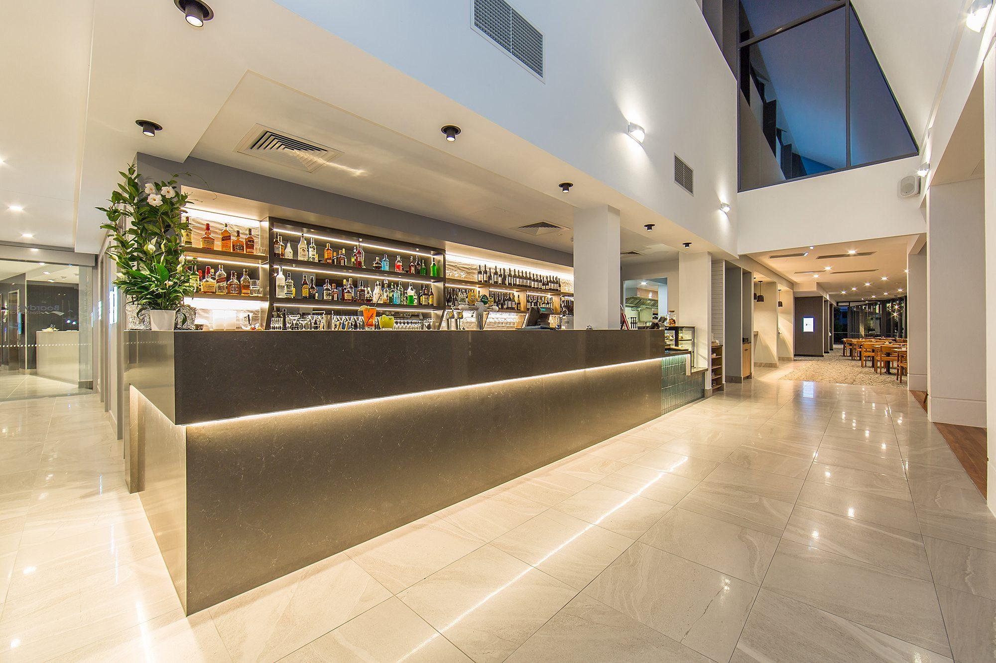 Bar with illuminated back-of-bar shelving and feature lighting