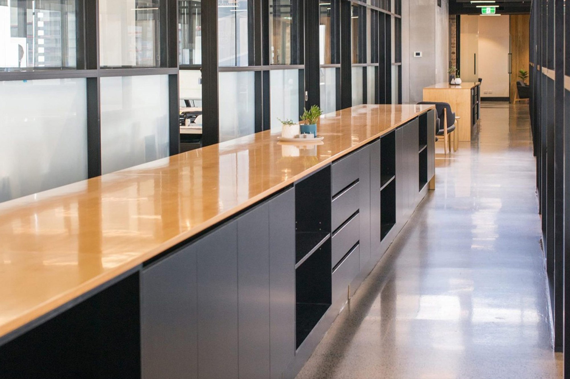 Kitchen and bench area with black ceiling and linear lighting
