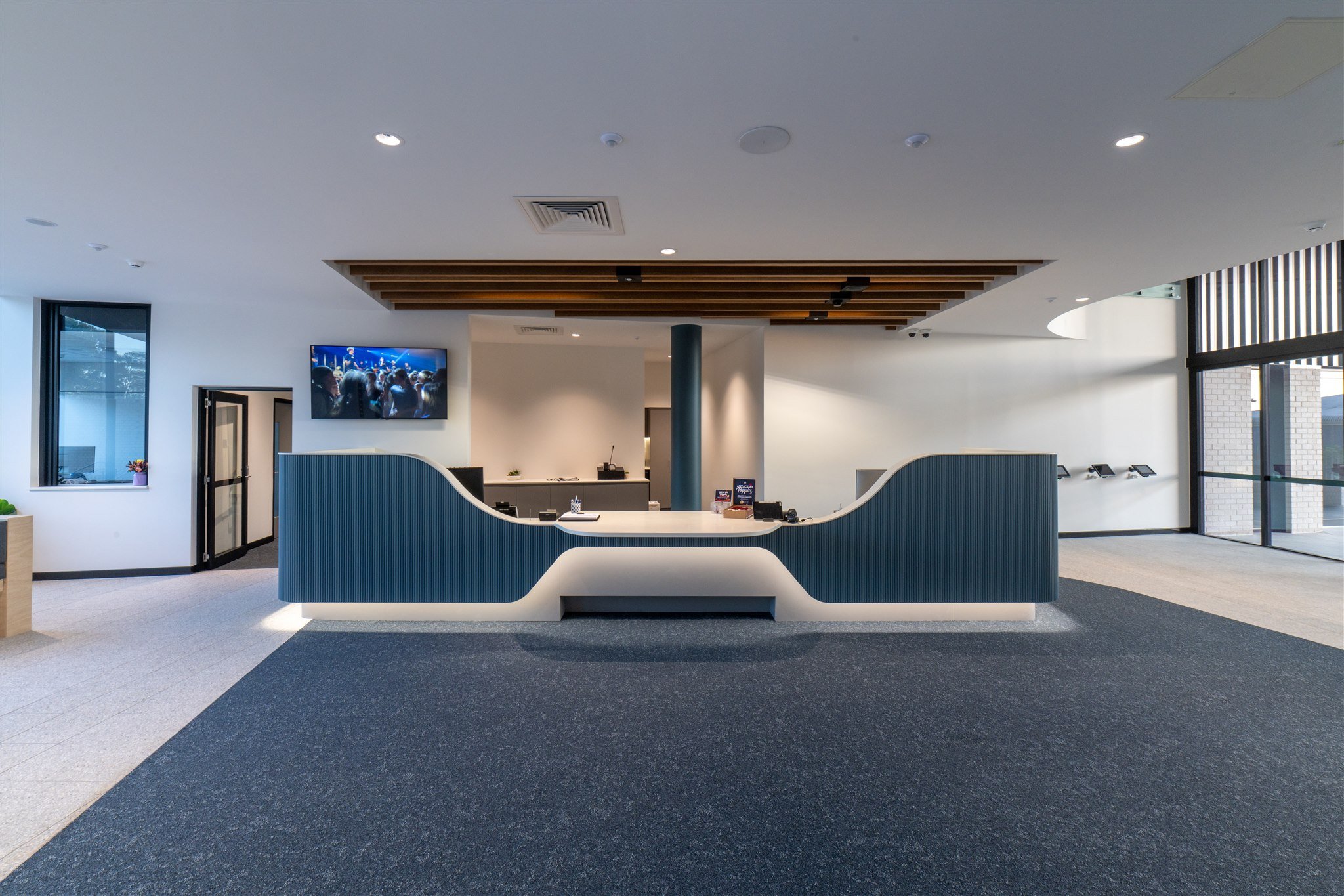 Bristol House curved reception desk beneath a sculpted ceiling