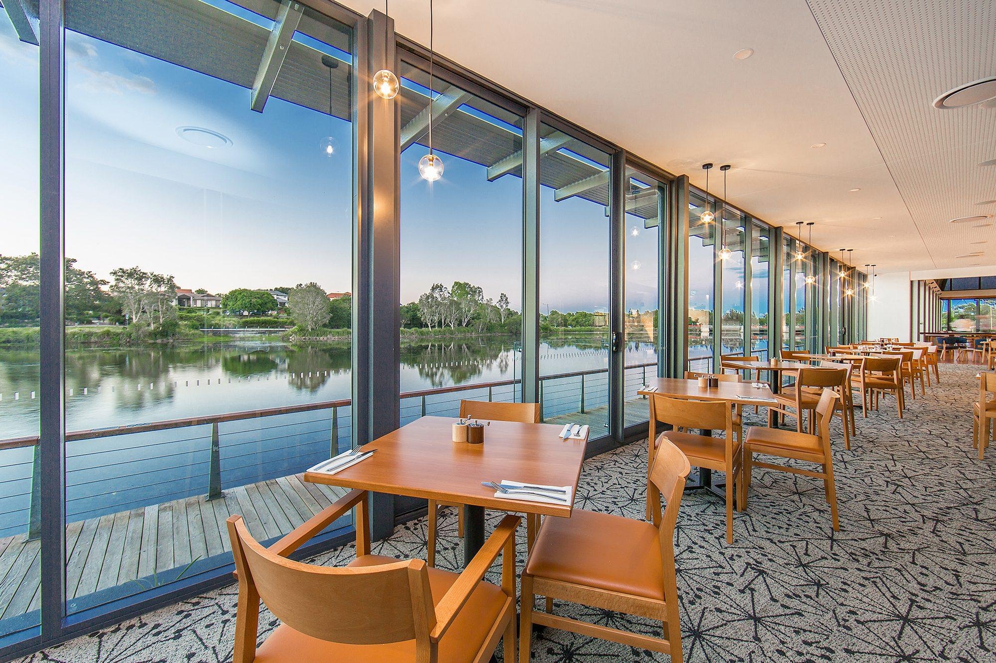 Waterside dining with pendant lighting and full-height glazing