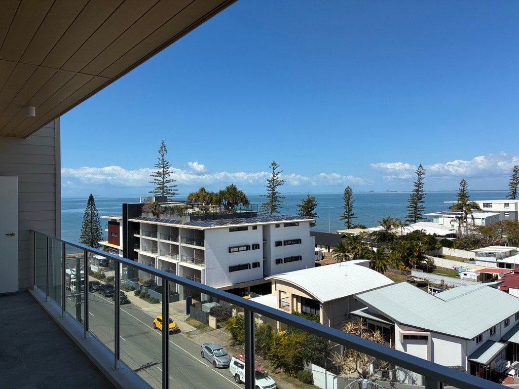 Balcony with glass balustrade overlooking the street and bay