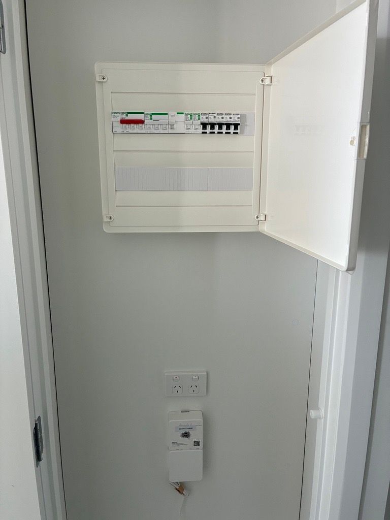 Apartment switchboard in a hallway cupboard with a power point and meter below