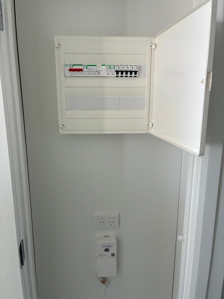Apartment switchboard in a hallway cupboard with a power point and meter below