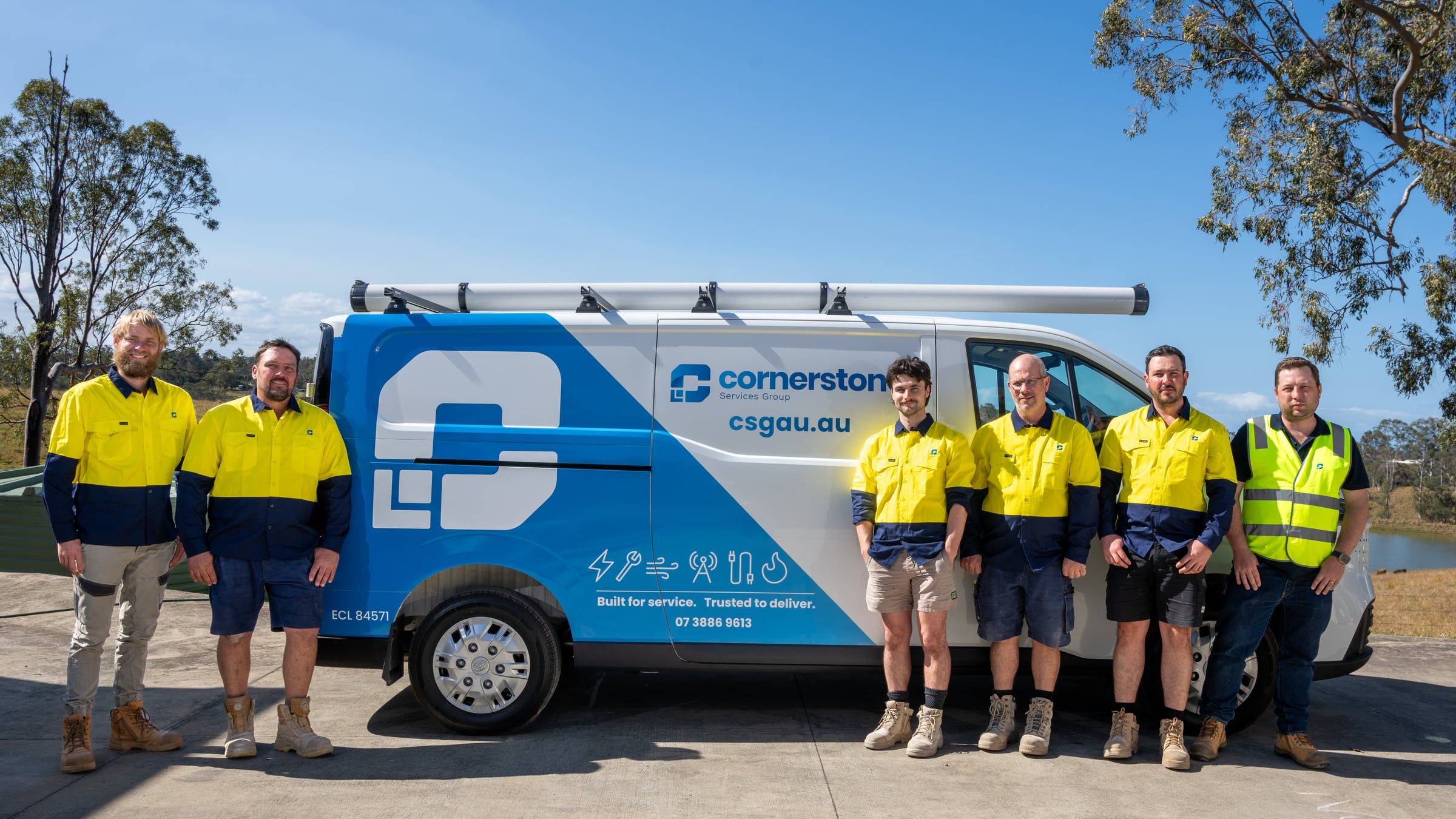 Cornerstone Services Group team in uniform beside a branded service van